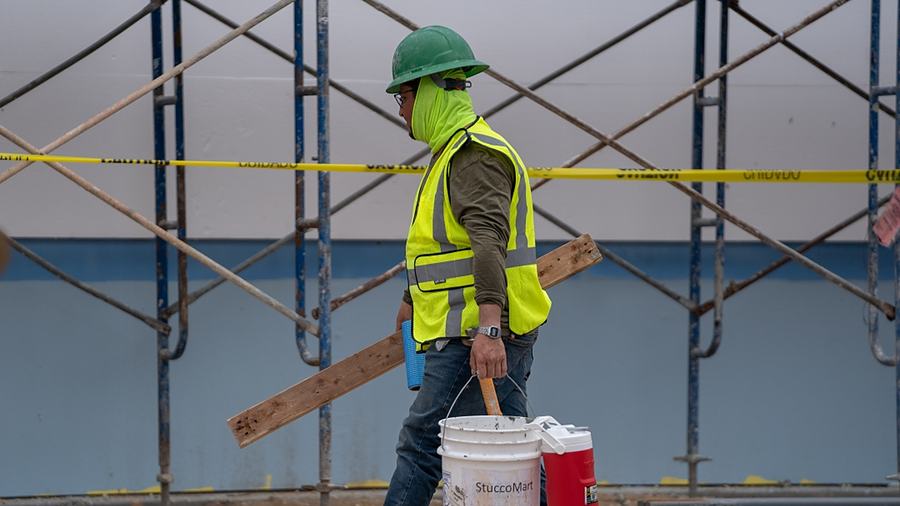 A construction worker carrying a bucket on a building site in Edinburg.