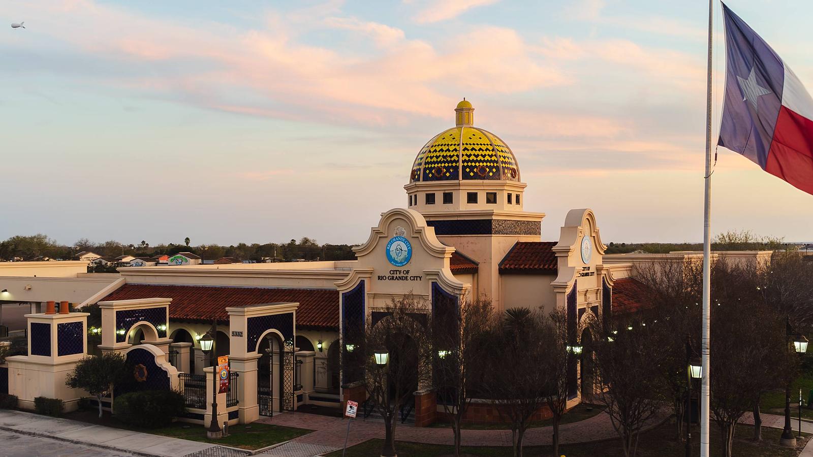 Rio Grande City Hall at dusk, its gold dome lit against a pink sky.